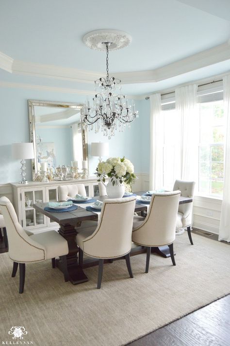 Blue-elegant dining-room-with-white-hydrangea-and-vertical-mirror-over-cream buffet