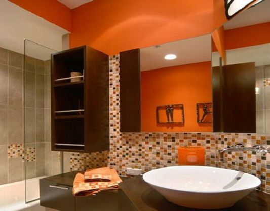 Orange bathroom wall paints combined with mosaic tiles backsplash .