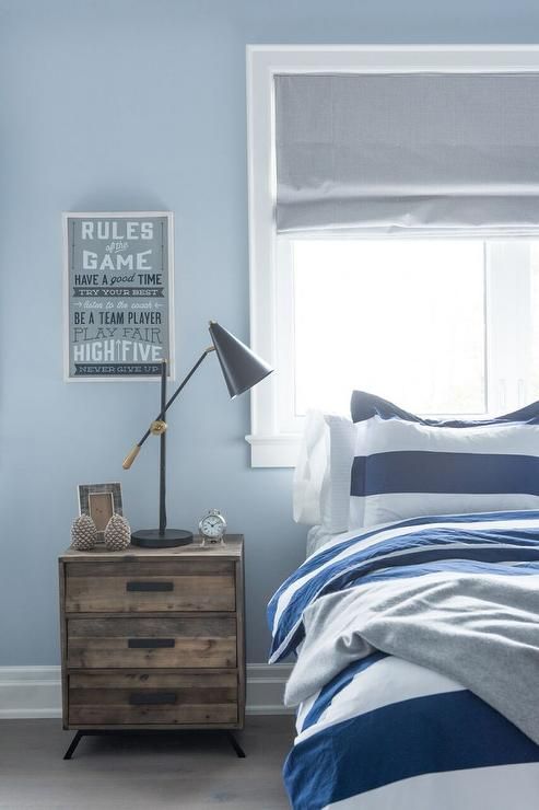 Blue and gray boy's bedroom features a wall painted blue framing a .