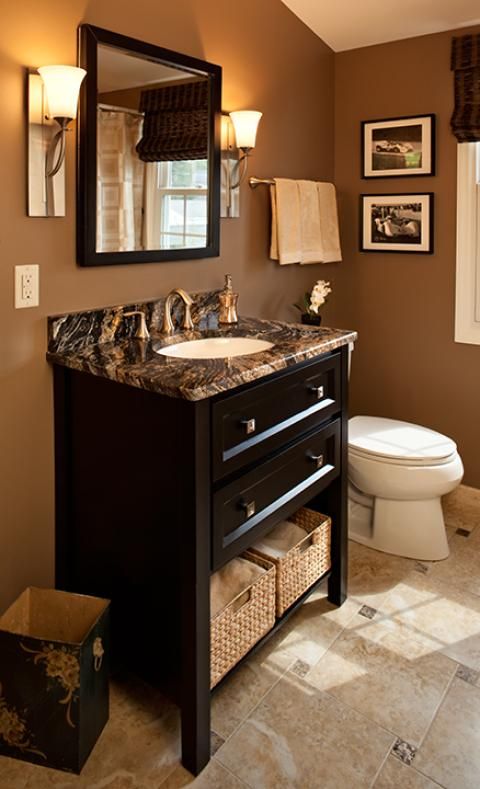 Traditional bathroom with brown and black marble countertop .