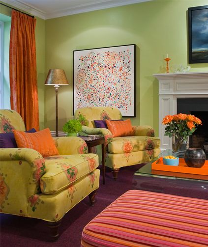 This green living room has orange and purple accents throughout .