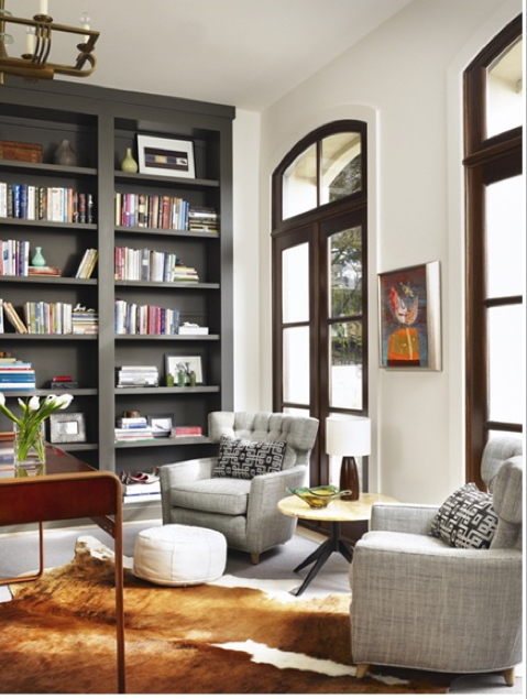 dark grey bookshelves stand out like furniture against white walls .