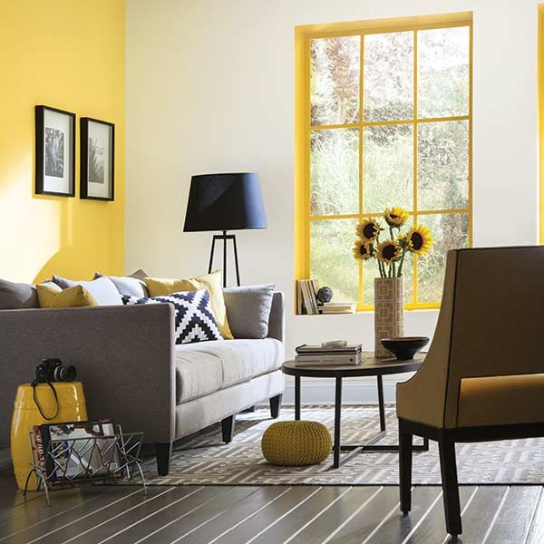 A painted window frame picks up a living area's yellow accent wall .