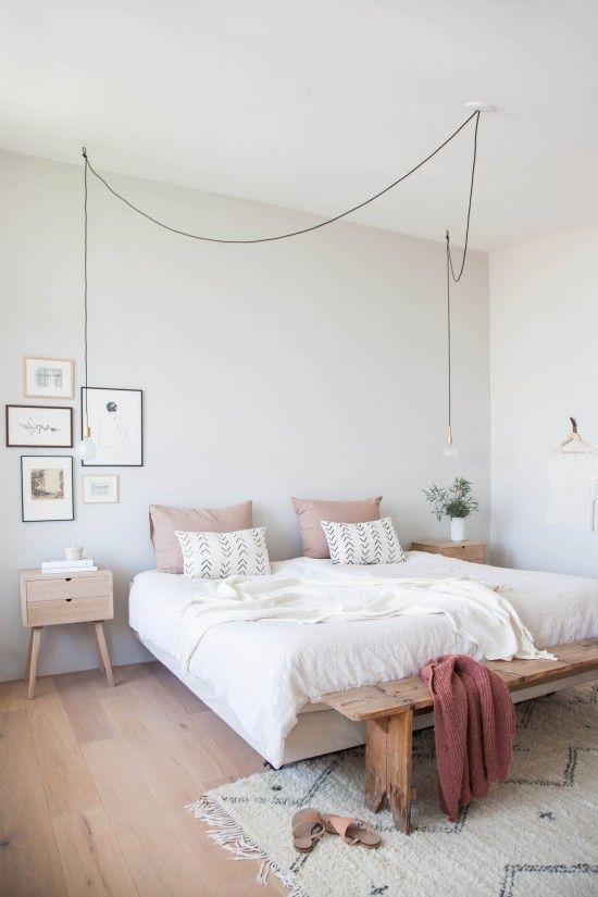 White Bedroom with light wood accents and muted pink tones .