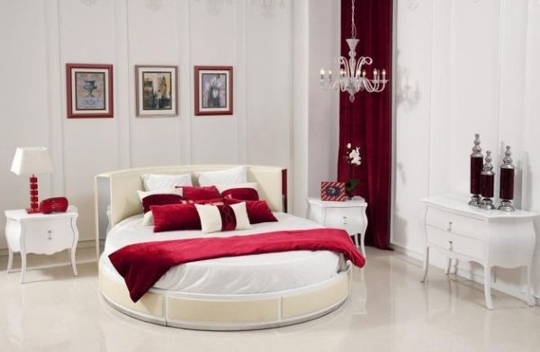 Modern bedroom in a white and red theme with a stylish circle bed .