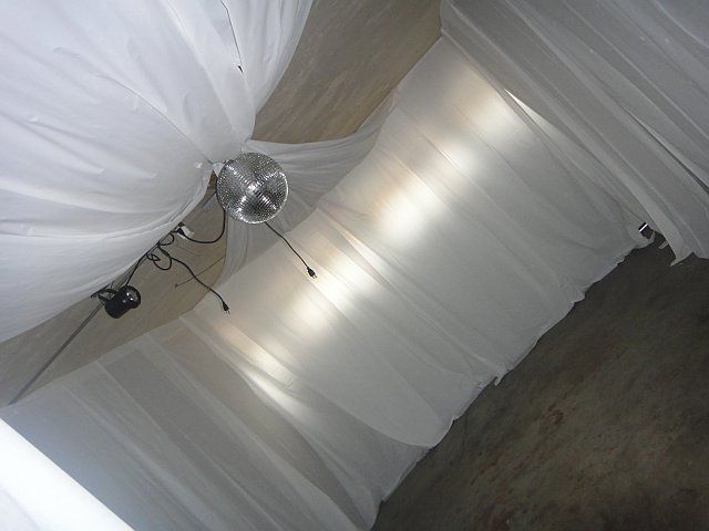 My garage transformed by plastic draping with help from a friend .