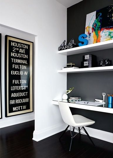 Dark charcoal feature wall, white shelves colourful art and decor .