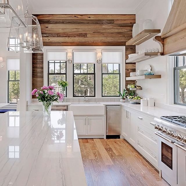 Beautiful wood paneling and floors to contrast with the white .